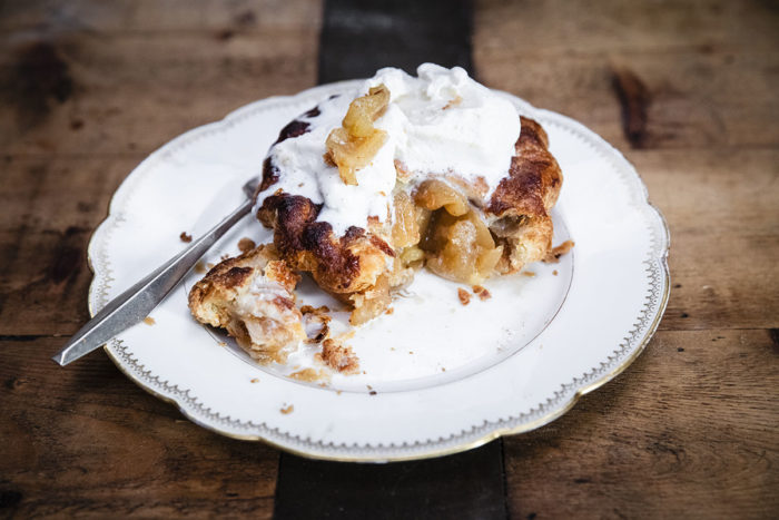 Chef Nancy Silverton's Baked apple pie with caramelized apples topped with vanilla gellato and served on a ceramic plate.